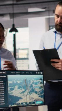 Mühendislerden oluşan bir ekip daha fazla yeşil enerji üretmek için elektrik şebekesi ve rüzgar çiftliği planını optimize etmek için beyin fırtınası yapıyor. Ar-Ge çalışanları elektrik hatları ve fütüristik rüzgar türbini simülasyonu, kamera B