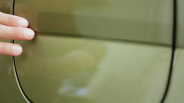 Park halindeyken şarj etmek için sıfır emisyonlu EV otomobilin giriş kapağını açan kişiye aşırı yakın çekim. Sürücü şarj edilebilir şarj edilebilir yeşil teknoloji elektrikli araç ile donatılmış