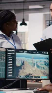 Ofisteki mühendisler yeşil enerji üretim teknolojisi testi yapıyorlar. Takım çalışma arkadaşları yenilenebilir enerji sektöründe biyolojik çeşitliliğin korunması için ileri teknolojili çözümler araştırıyor, kamera B