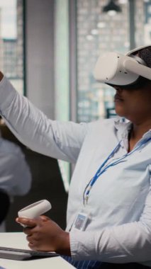 Alternatif enerji teknolojisi kullanarak güneş enerjili cihaz tasarımı yapmak için VR kulaklık kullanan bir teknisyen. İşçi çevre dostu güneş cihazları geliştirmek için sanal gerçeklik simülasyonu kullanır, kamera B