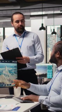 Ofisteki mühendisler yeşil enerji üretim teknolojisi testi yapıyorlar. Takım çalışma arkadaşları yenilenebilir enerji sektöründe biyolojik çeşitliliğin korunması için en son çözümleri araştırıyorlar, kamera A