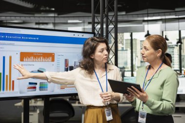 Bir strateji oluşturan ve çok uluslu şirkette fikir alışverişinde bulunan kadın meslektaşlar, başarı ve profesyonel gelişimi sağlamak için performans göstergelerini gözden geçiriyorlar. Güçlü zihniyet..