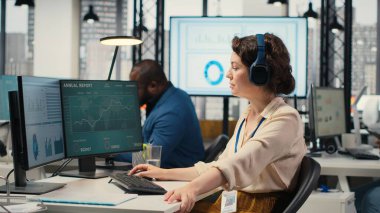 Ofis yöneticisi görevleri çözmek, iş istasyonundaki performans ölçümlerini izlemek için kulaklık üzerine odaklanmış müzik kullanır. Girişimciliğin üretkenliğini ve başarısını sağlamak için idari görevler. Kamera B.