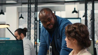 Rapor oluşturmak için aylık veri grafiklerini inceleyen çeşitli ofis çalışanları, yenilikçiliği teşvik etmek ve şirket performansını artırmak için iş stratejisi ve analizler uyguluyorlar. İş birliği. Kamera B.