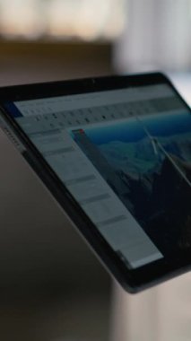Rüzgâr türbini CAD tasarımı üzerinde çalışmak için tablet kullanarak sürdürülebilir enerji araştırması yaparak, ofisteki mühendisi kapat. İşçi cihaz üzerinde rüzgar enerjisi jeneratörünün dijital modellemesini yapıyor, kamera B