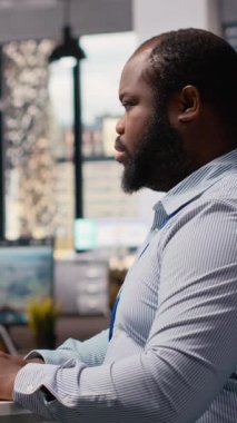 Ofisteki mühendis yapay zeka kullanarak rüzgar türbini bileşeni CAD tasarımı üzerinde çalışıyor. Afrika kökenli Amerikalı adam yapay zeka, kamera B kullanarak rüzgar enerjisi jeneratörünün dijital modellemesini yapıyor.