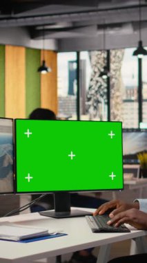 Yenilenebilir enerji üretimi için tasarlanmış yeşil ekran bilgisayarda fütüristik rüzgar türbini üzerinde çalışan bir araştırmacı. Ofisteki Afrikalı Amerikalı adam son model VAWT 'leri, kamera A' yı araştırmak için model bilgisayar kullanıyor.