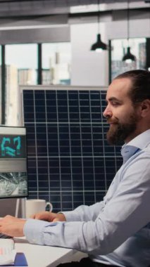 Ar-Ge uzmanı temiz enerji çözümleri geliştirir, kahve içer, iş arkadaşıyla konuşur. Mühendis iş arkadaşıyla sohbet ediyor, içecekten keyif alıyor, yenilenebilir enerji üretimini PC, kamera A 'da optimize ediyor.