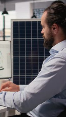 Ar-Ge araştırmacısı güneş yeşili enerji sistemlerini incelemek için belge dosyalarına bakıyor. Fotovoltaik karbon ayak izini geliştirmek için CAD yazılımı kullanan mühendis, kamera A