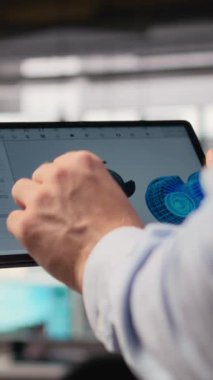 Rüzgâr türbini sürdürülebilir yapmak ve karbon ayak izini azaltmak için CAD uygulamasını tablet üzerinde kullanarak mühendisi kapat. Dokunmatik ekran cihazını araklayan Ar-Ge uzmanı, çevre dostu yel değirmeni parçalarına bakıyor, kamera A