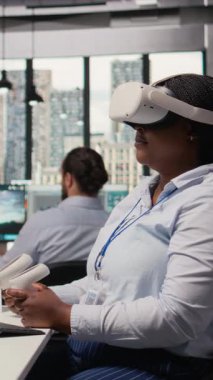 Yenilikçi güneş enerjili cihaz prototipi geliştirmek için sanal gerçeklik simülasyonu kullanan mühendis. Ar-Ge çalışanı taşınabilir güneş paneli cihazını incelemek için VR kulaklık kullanıyor. Kamera A