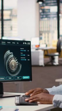 Rüzgâr türbininin aerodinamiğini optimize etmek için CAD yazılımı kullanan teknisyen karbon ayak izini azaltıyor. Afrika kökenli Amerikalı adam, çevre dostu yel değirmeninin gelişmiş materyallerini test ediyor.