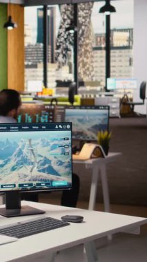 İşçi ofise girer, temiz enerji sistemlerini geliştirmek için elektrik şebekesi ve rüzgar çiftliği tasarım optimizasyon araçları kullanır. Teknisyen elektrik hatları ve fütüristik rüzgar türbini simülasyonu üzerinde çalışmaya başladı. Kamera A