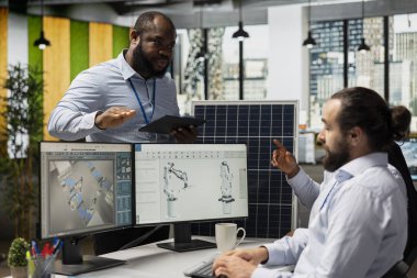 Yönetici, ileri üretim hatlarıyla sürdürülebilir güneş paneli imalatını geliştiren çalışanları denetliyor. Takım lideri ve bilim adamı temiz güneş enerjisi ekipmanı üretim sürecini geliştirdiler