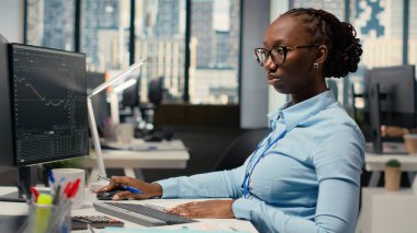 Aksesuar şirketinin sermaye analisti üç aylık kazançları değerlendirip gelecekteki hisse senedi değerini belirlemek için not alıyor. Tüccar yatırımları iyileştirmek ve bilgi yazmak için mali analiz yürütüyor.