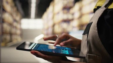 E-ticaret için tedarik zincirini denetleyen dağıtım merkezi çalışanını kapatın. Tabletteki lojistik ve nakliye verilerinin gözden geçirilmesi, sipariş yerine getirilmesi için izleme etiketlerinin güncellenmesi. Kamera A.