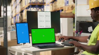 Büyük dağıtım merkezi çalışanı kargo detaylarını münferit ekran ile onaylıyor, e-ticaret tamamlama merkezinde sipariş işlemleriyle uğraşıyor. Büyük işletmeler endüstriyel faaliyetler yapıyor. Kamera B.