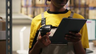 Çalışan, dolum merkezindeki karton kutularda barkod tarayıcısı kullanıyor. Organize raf, paket etiketleri ve güzergah planlaması verimli dağıtım ve sevkiyat desteği. Lojistik merkezi. Kamera B.