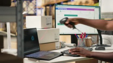 Siyah çalışan, paket izleme verimliliğini artırmak için yapay zeka araçlarıyla çalışıyor, makine öğrenme ve paketleme izleme bilgilerini kullanarak depodaki sorunsuz dağıtım işlemlerini sağlama alıyor. Kamera B.