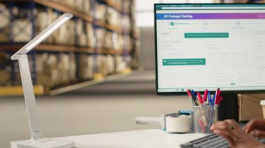 Yelek giyen Afro-Amerikan kadın barkodları tarıyor, paket sevkiyatı için, nakliye etiketlerinin takip edilmesini sağlıyor. Dağıtım için kargo bilgilerini onaylayan kasklı bir kadın. Kamera B.