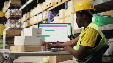 Afro-Amerikan işçiler hava yolu faturası detaylarını uyguluyor ve kutulardaki etiketleri tarıyor. Paket takibi, yanlış etiketler ve kayıtlar büyük işletmeler için nakliye işlemleri. Kamera A.