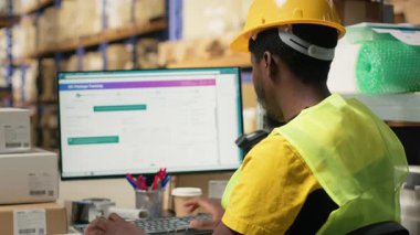 Kara depo katibi dağıtım sistemi için takip yazılımı envanter verilerini inceliyor. Lojistik merkezi deposunda organize raflar var. Çevrimiçi perakende satış ve tedarik zinciri. Kamera B.