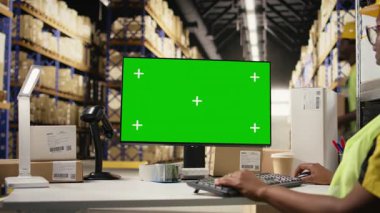 Afrika kökenli Amerikalı bir kadın polis memuru, depo ortamında çelik yelek ve miğfer takıyor. E-ticaret perakende operasyonları büyük kutularla çevrili. Kamera A.