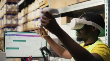 Kara depo memuru sanal gerçeklik kulaklığını online alışveriş siparişleri için kullanıyor, envanterden kargo malları hazırlıyor ve bilgisayar yazılımındaki paket durumunu izliyor. İşlem emri. Kamera A.