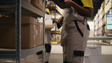Afro-Amerikan e-ticaret işçisi nakliye etiketlerinin numaralarını tarıyor, envanter kayıtları ve sevkiyat detaylarını kaydediyor. Palet dağıtım operasyonlarıyla ilgilenen genç bir adam. Kamera A.