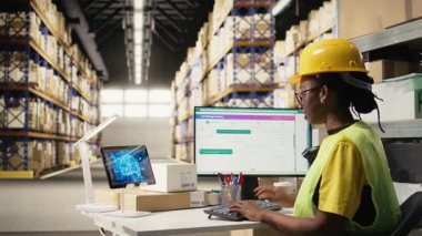 Kara Depo çalışanı, teslimat ve sipariş işlemlerine yardımcı olması için yapay zeka sanal asistanıyla envanter lojistiği yönetiyor. Çevrimiçi alışveriş perakende faaliyeti. Kamera A.