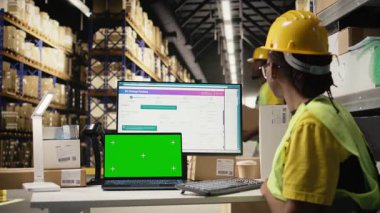 Kopya alanının yanındaki sevkiyatları takip eden Afrikalı Amerikalı işçiler, organize raflar ve paletler ile depo operasyonları. Doğru lojistik ve tam zamanında sipariş. Kamera A.