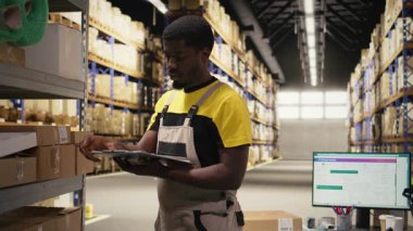 Kadın çalışanlar depodaki kutulara yapışkan nakliye etiketleri yapıştırıyor, paketleri yanlış takip numaralarıyla etiketliyor ve sorunsuz bir şekilde işleme tabi tutuluyor. Kamera A.