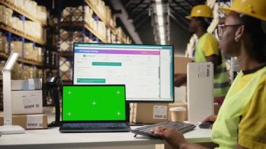 Stok odası çalışanı telefondaki kopyalara bakıyor ve bilgisayar yazılımındaki paketleri takip ediyor, e-ticaret büyük şirketleri için ithalat ihracat işlemleriyle uğraşıyor. Depoda sipariş yerine getirildi. Kamera A.