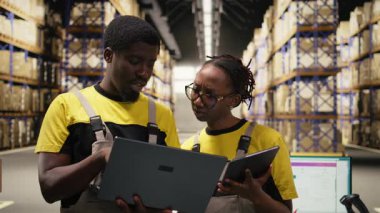 Geniş işletme deposu personeli sipariş işlemlerini dizüstü bilgisayarla, dağıtım prosedürleriyle ve depolama merkezinin raflarıyla hallediyor. Paketleme. Kamera A.