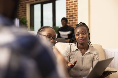 İnsan kaynakları uzmanları çalışanların performans ölçümlerini değerlendirir ve modern ofiste önemli sonuçları tartışırlar. Seçici odak noktası siyah iş kadınları, dikkatle dinlemek Girişimci şirket toplantısı sırasında.