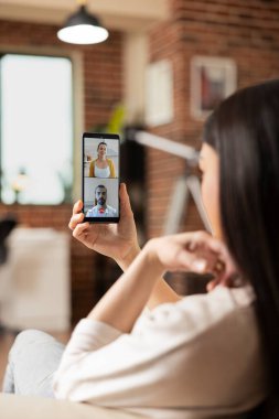 Kadın girişimci cep telefonu tutuyor, iş ortaklarıyla sanal görüşme yapıyor, başlangıç stratejilerini tartışıyor. Kadın yönetici, uzak Kafkas çalışanlarıyla video görüşmesi için mobil aygıt kullanıyor.