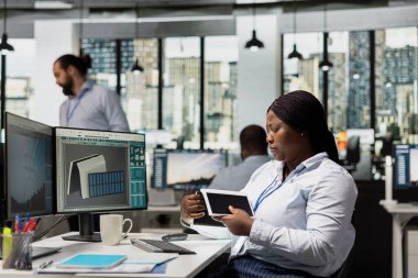 Ofisteki ürün tasarımcısı yenilenebilir enerji projeleri için kompakt güneş cihazı üretiyor. Modern işyerindeki mühendis çevresel etkiyi azaltmak için güneş aygıtı prototipi tasarladı