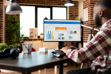 Afrika kökenli Amerikalı iş adamı, iş mali raporlarını gözden geçiriyor ve kârlı strateji planları hazırlıyor. Odaklanmış siyah erkek girişimci yeni kurulan şirketin mali kayıtlarını inceliyor