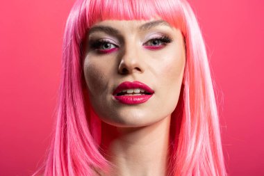 Kalın makyajlı pembe saçlı kadın modelin portresi stüdyoda doğrudan kameraya bakıyor. Özgüven ve zarafet saçan, cilt bakımını ön plana çıkaran muhteşem beyaz kadın..