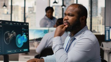 Teknisyen rüzgar çiftliği yerleşimlerini planlamak için yazılım kullanıyor, ideal türbin yerleşimlerini belirliyor. Ar-Ge çalışanı, Yel değirmenleri tarım konfigürasyonları, kamera B için CAD programı üzerinde çalışıyor.