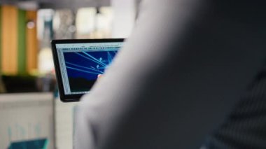 Ofisteki elektrik santrallerini tasarlamak için tablet kullanan mühendisi kapatın. Ar-Ge uzmanı iletim kulesi sistemlerini optimize etmek için cihaz üzerinde CAD yazılımı kullanır. Kamera A