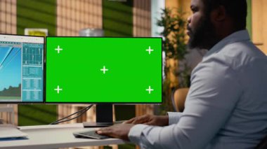 Teknisyen ofisteki yeşil ekranda güç hattı CAD tasarımı üzerinde çalışıyor. Ar-Ge çalışanı iletim kulesi sistemlerini optimize etmek için krom anahtar bilgisayarda program kullanır, kamera B