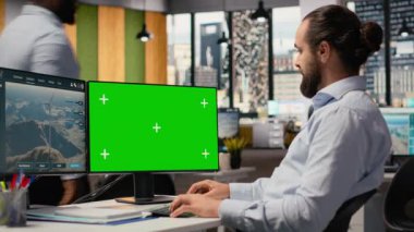 İşçi, gelişmiş VAWT rüzgar çiftliği düzenini optimize etmek ve temiz enerji üretimini artırmak için yeşil ekran modelleme PC kullanır. Teknisyen fütüristik rüzgar türbini simülasyonu için krom anahtar bilgisayar kullanır, kamera B