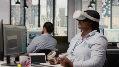 Yenilikçi güneş enerjili cihaz prototipi geliştirmek için sanal gerçeklik simülasyonu kullanan mühendis. Ar-Ge çalışanı taşınabilir güneş paneli aygıtını incelemek için VR kulaklık kullanıyor. Kamera B