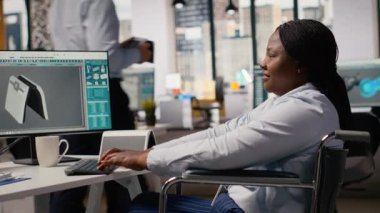 Engelli teknisyen alternatif enerji teknolojisiyle güneş enerjili cihaz tasarımı yapıyor. Belden aşağısı felçli bir işçi. Kapsamlı ofiste çevre dostu güneş cihazları yapıyor. Prototipler, kamera B