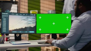 Mühendis, ofisteki izole ekran bilgisayarında güç hattı CAD tasarımı üzerinde çalışıyor. Ar-Ge uzmanı, iletim kulesi sistemlerini optimize etmek için bilgisayar üzerinde yazılım kullanır. Kamera B