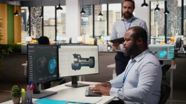 Rüzgâr türbini tasarımını optimize etmek için CAD uygulamasını kullanarak karbon ayak izini azaltan bir mühendis yöneticisi. Ar-Ge ekip lideri ve işçi, çevre dostu yel değirmeni parçaları için gelişmiş materyalleri test ediyor.