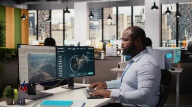 Ar-Ge sürdürülebilirlik mühendisi ofiste rüzgar türbini simülasyonu üzerinde çalışıyor. Bilgisayar üzerinde CAD yazılımı kullanan araştırma ve geliştirme departmanı çalışanı yenilenebilir enerji yel değirmeni mühendisliği yapıyor.