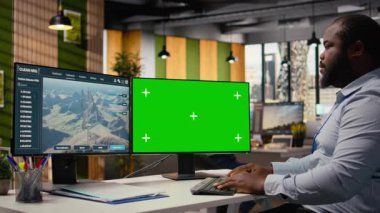 Temiz enerji üretimi için tasarlanmış izole ekran bilgisayarda fütüristik rüzgar türbini konsepti üzerinde çalışan teknisyen. Ofisteki adam modern VAWT yeniliklerini araştırmak için krom anahtar bilgisayar kullanıyor. Kamera A.