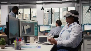 Yenilikçi güneş enerjili cihaz prototipi geliştirmek için sanal gerçeklik simülasyonu kullanan mühendis. Ar-Ge çalışanı taşınabilir güneş paneli cihazını incelemek için VR kulaklık kullanıyor. Kamera A